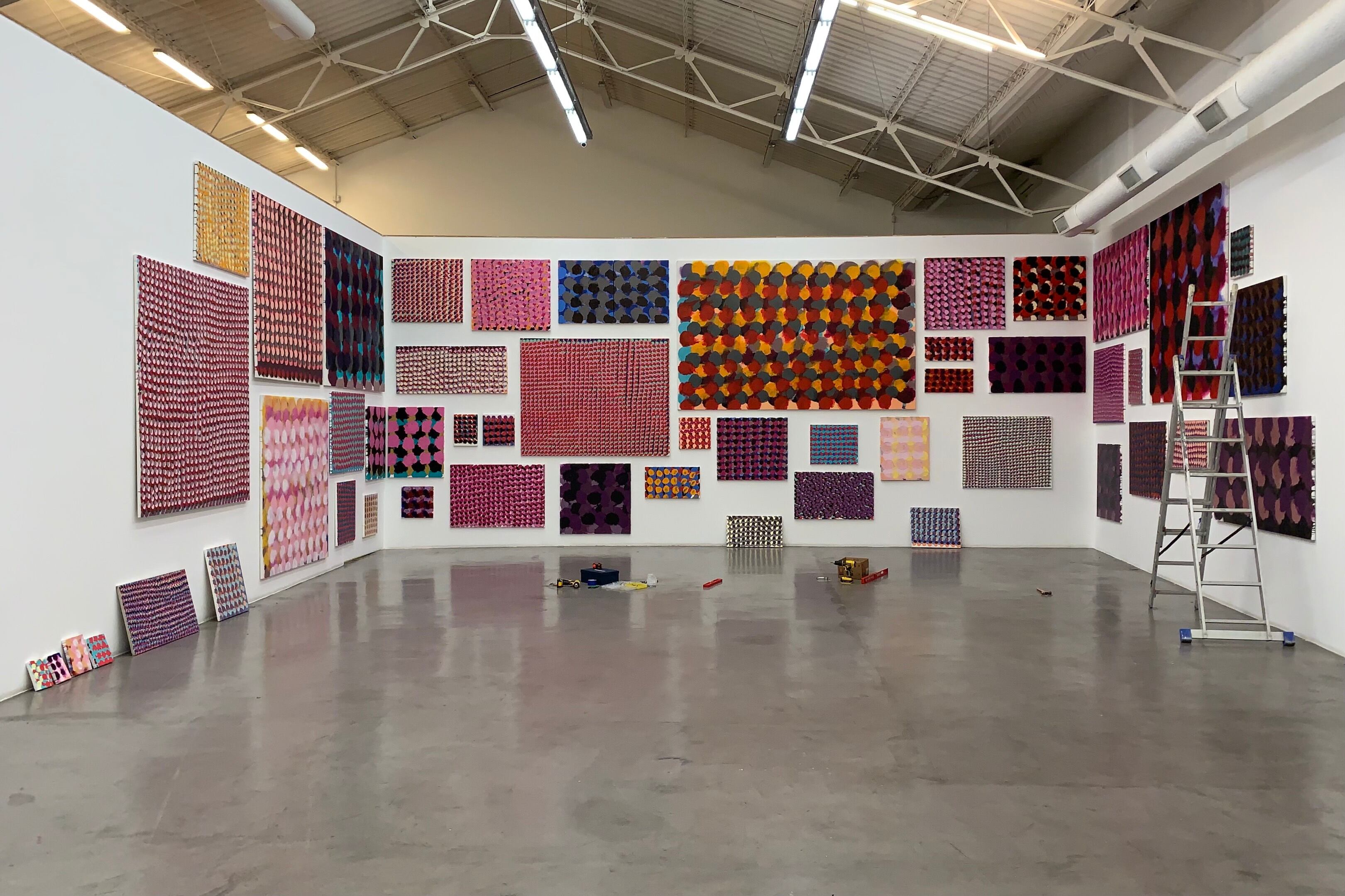 Muestra de Ballesteros en pleno montaje. Abajo: Uno de los cuadros de Guillermo Iuso.