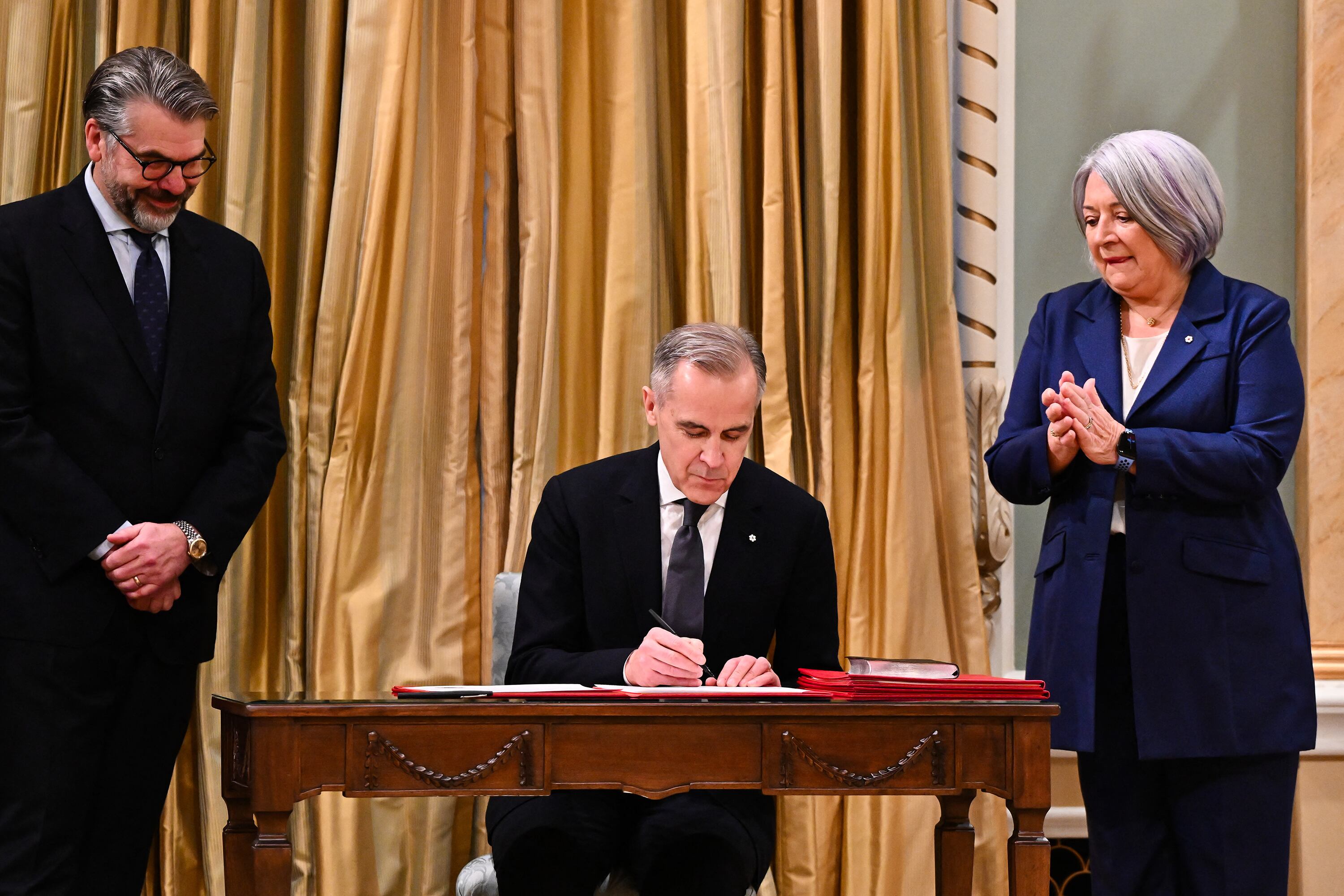 Carney firma un documento al asumir como primer ministro de Canadá.
