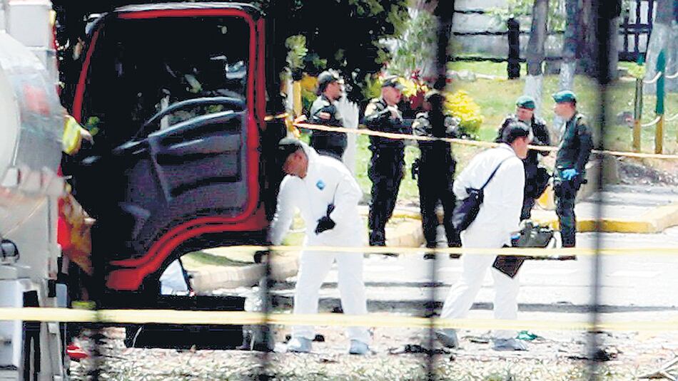 Expertos forenses trabajan en el lugar de la explosión en la academia policial General Santander de Bogotá.