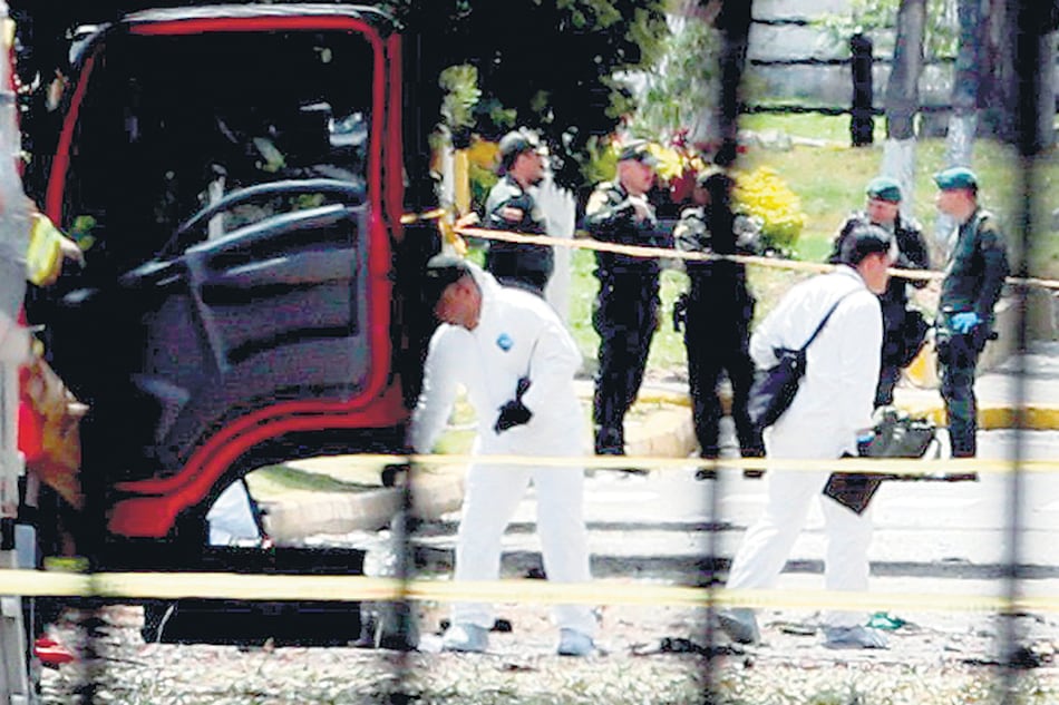 Expertos forenses trabajan en el lugar de la explosión en la academia policial General Santander de Bogotá.
