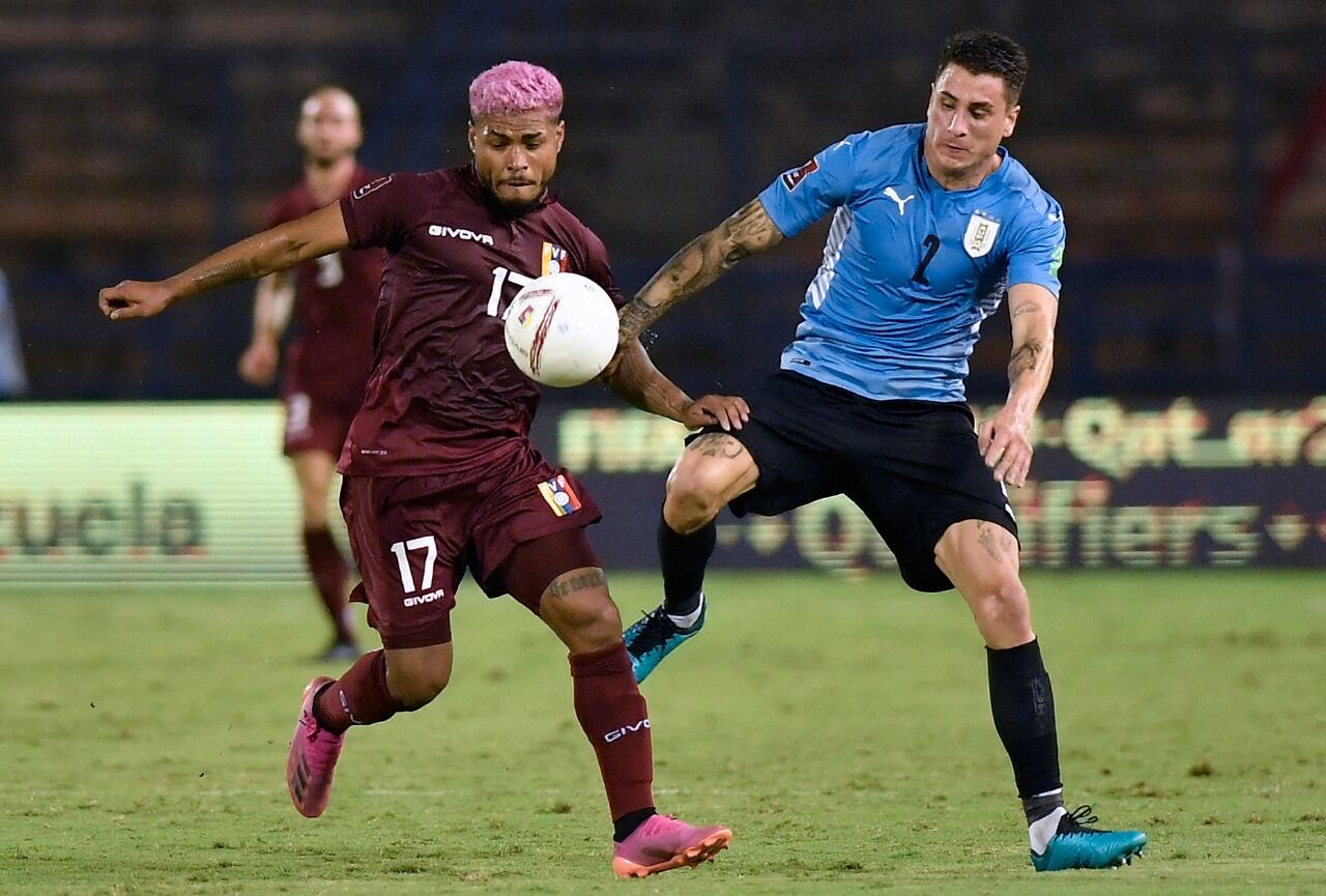 El uruguayo José María Giménez y el venezolano Josef Martínez disputan la pelota.