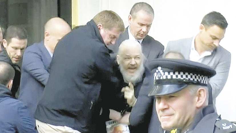 Assange es arrastrado por policías a un patrullero en la entrada de la embajada de Ecuador.