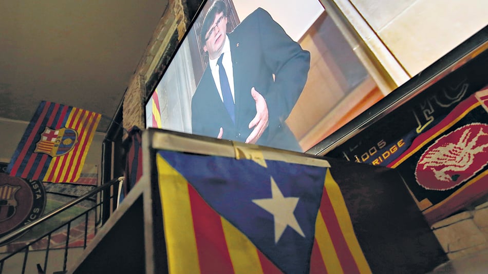 La pantalla gigante de un bar de Barcelona muestra la imagen de Puigdemont dando un mensaje a los catalanes.