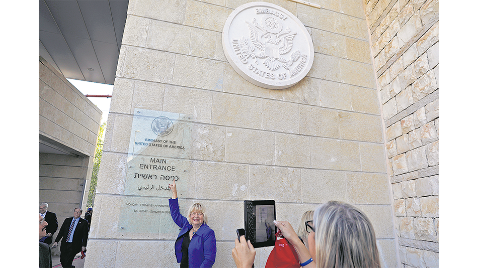 Turistas visitan la entrada de la embajada en Jerusalén.
