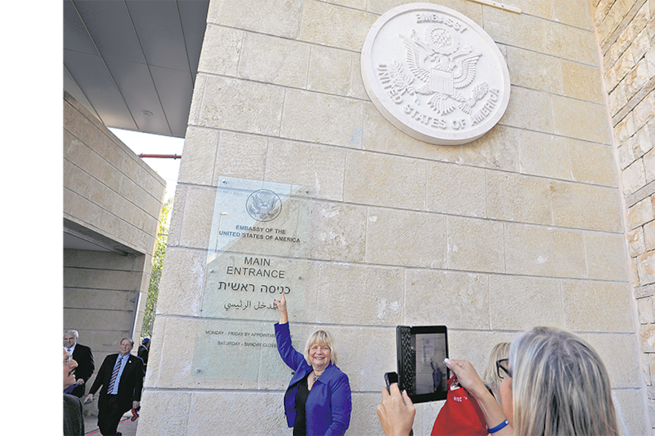Turistas visitan la entrada de la embajada en Jerusalén.