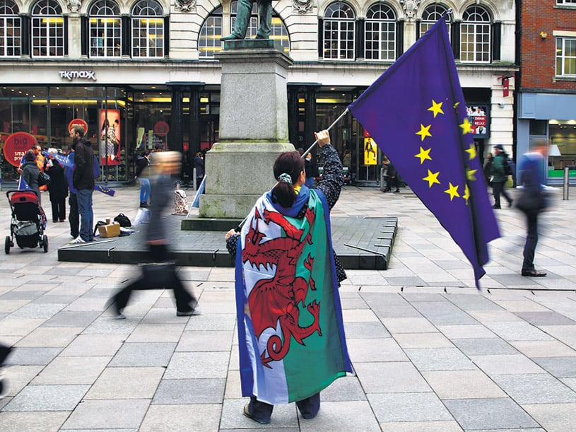 Una manifestante protesta contra la puesta en marcha del Brexit con las banderas de la UE y de Gales. 