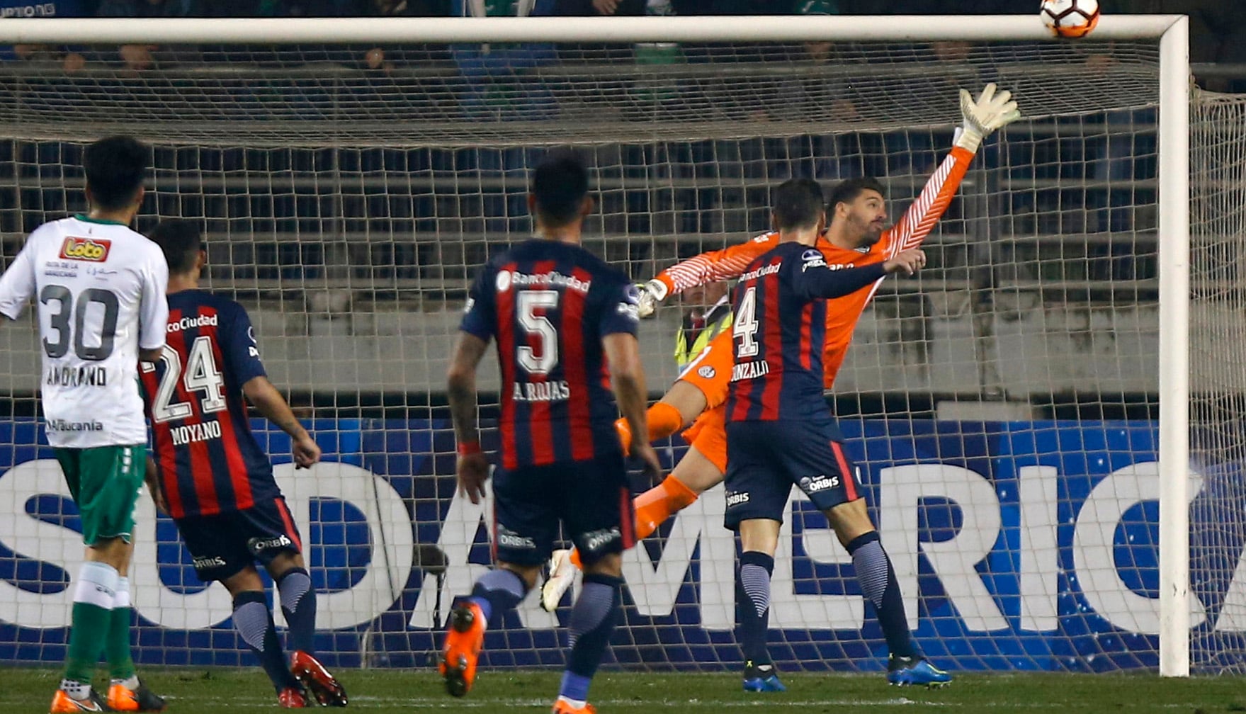 Navarro vuela sobre su izquierda para mandar al corner el remate de Abalos. El arquero fue la figura del partido.