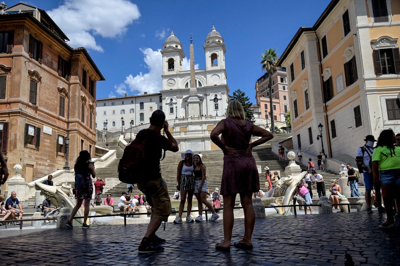 Jóvenes turistas disfrutan la tarde de verno en Piazza di Spagna, en Roma.