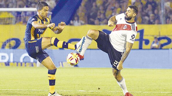Caruzzo disputa la pelota con Pratto. Central y River igualaron en Arroyito.