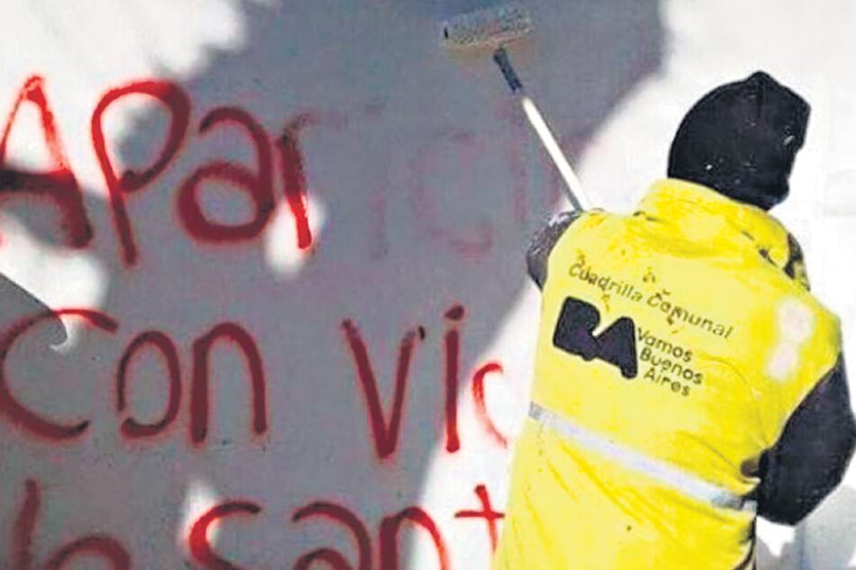 Un trabajador de la ciudad limpia pintadas que piden por la aparición de Santiago Maldonado.