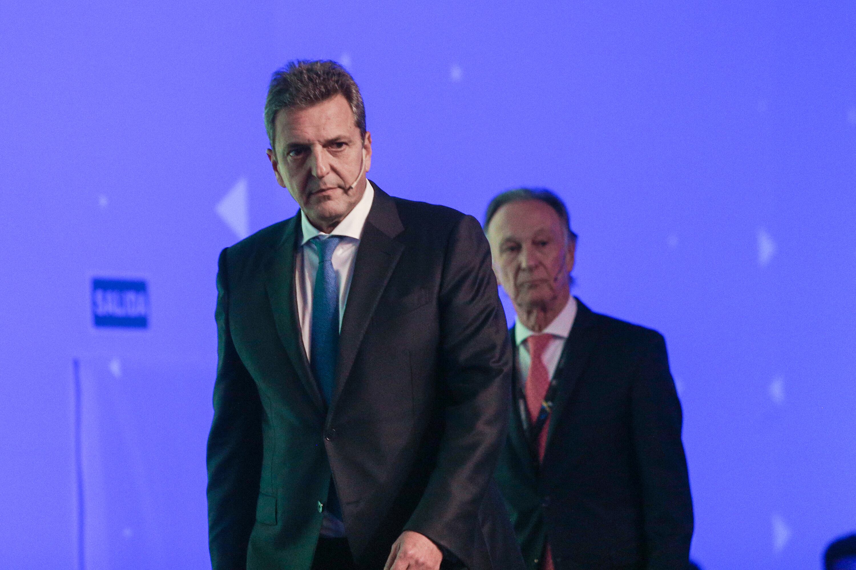 Sergio Massa, al subir al escenario de La Rural, seguido por Gustavo Weiss.