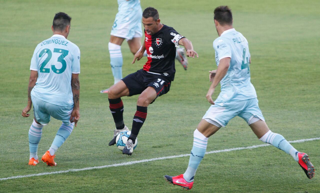 Maxi Rodríguez busca maniobrar entre dos marcadores de Racing.