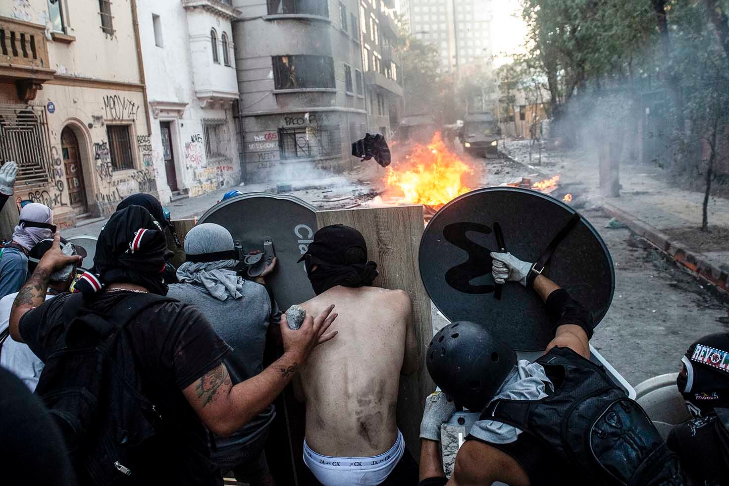 1.Barricadas en las calles de Santiago durante la protesta contra Piñera. 2. Represión de la policía antidisturbios en Viña del Mar. (AFP)