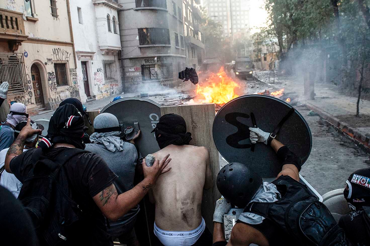 1.Barricadas en las calles de Santiago durante la protesta contra Piñera. 2. Represión de la policía antidisturbios en Viña del Mar. (AFP)