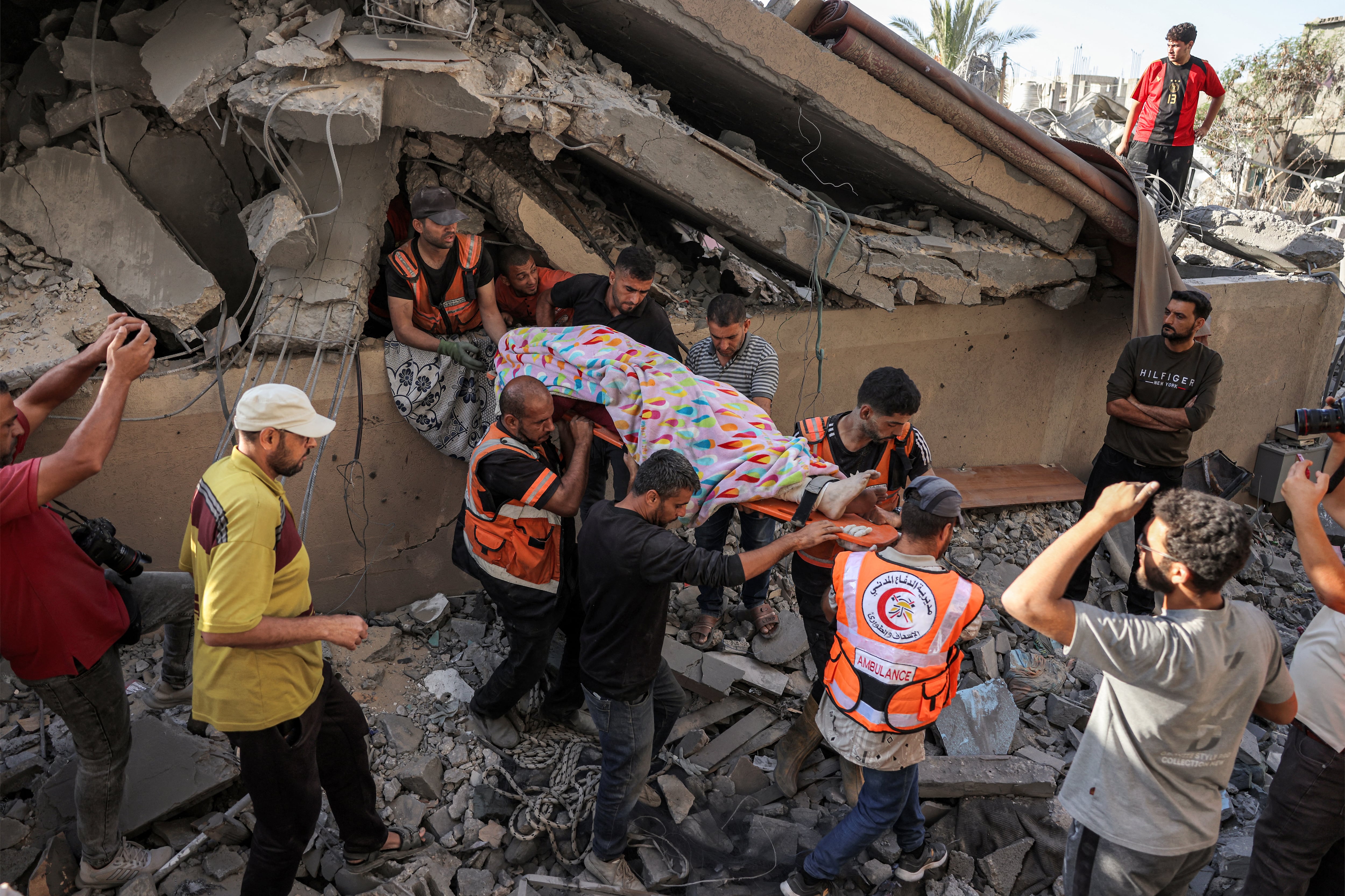 Resctistas extraen un cadaver de las ruinas de un edificio en Khan Yunis.