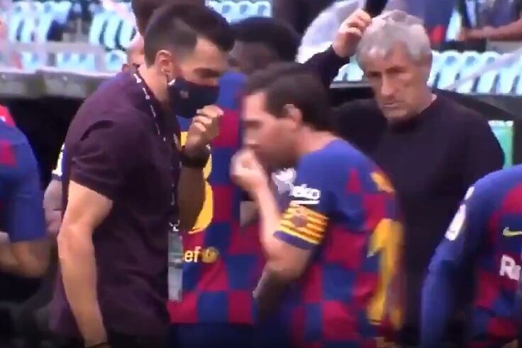 Messi se tapa la boca para contestarle a Sarabia. Detrás, el DT observa.