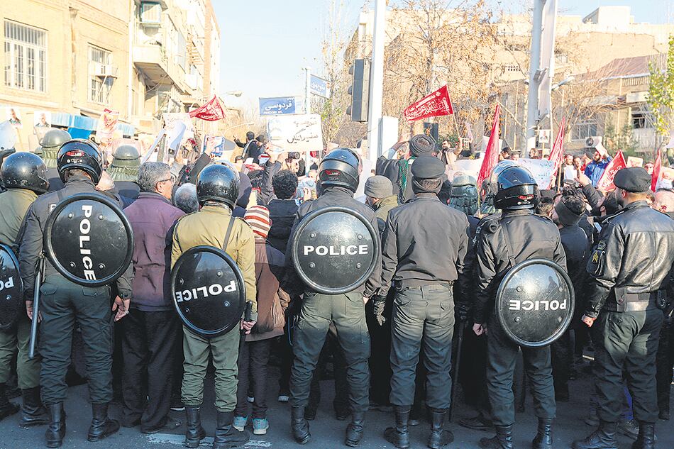 Manifestación frente a la embajada británica en Teherán, rodeada por un importante cordón policial.