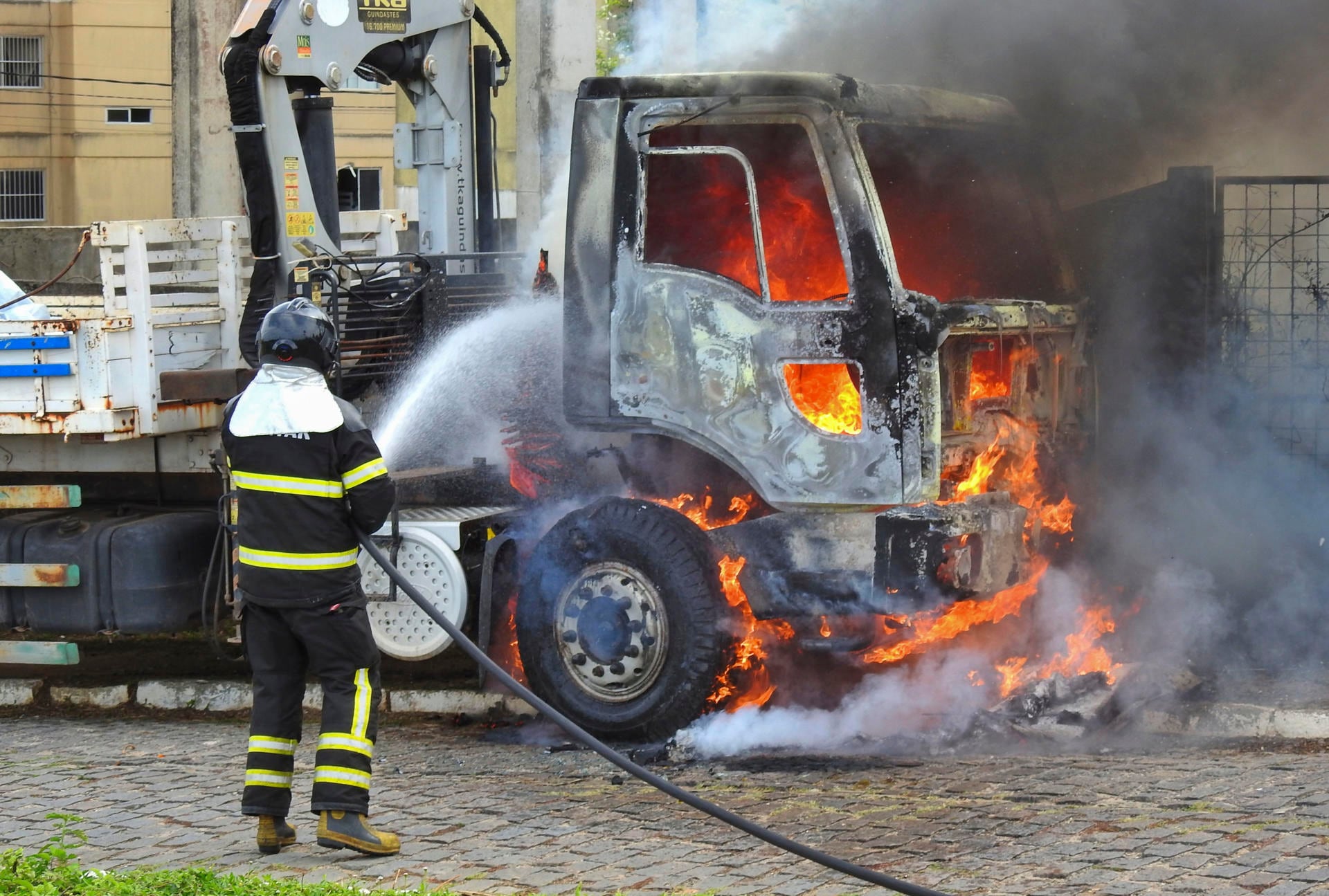 Un bombero intenta controlar el fuego de un vehículo en llamas en Parnamirim.