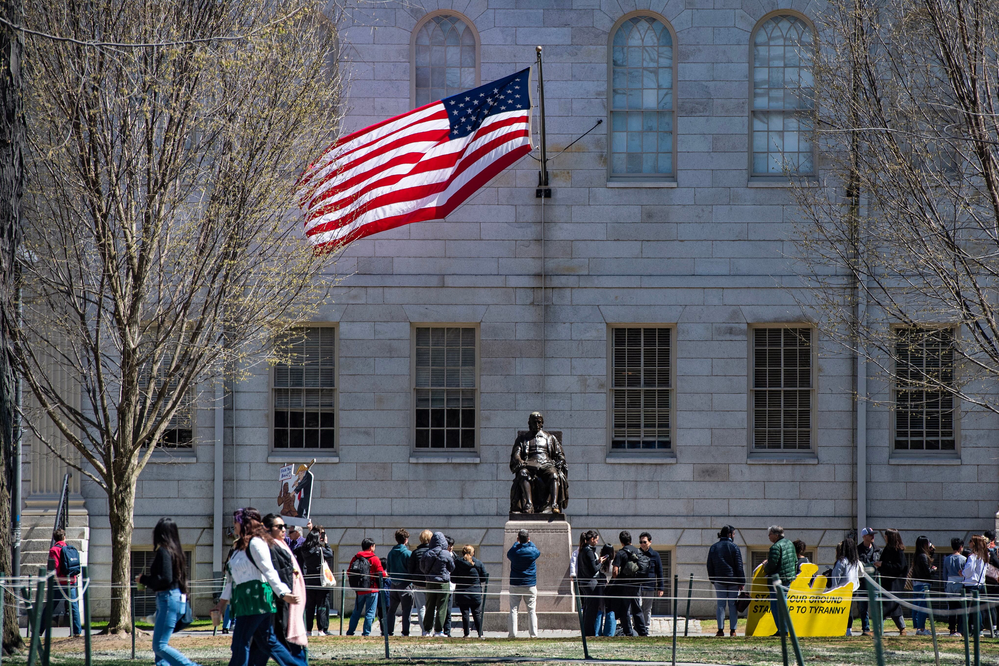 Manifestantes con pancartas se congregaron alrededor de la estatua de John Harvard en Massachusetts