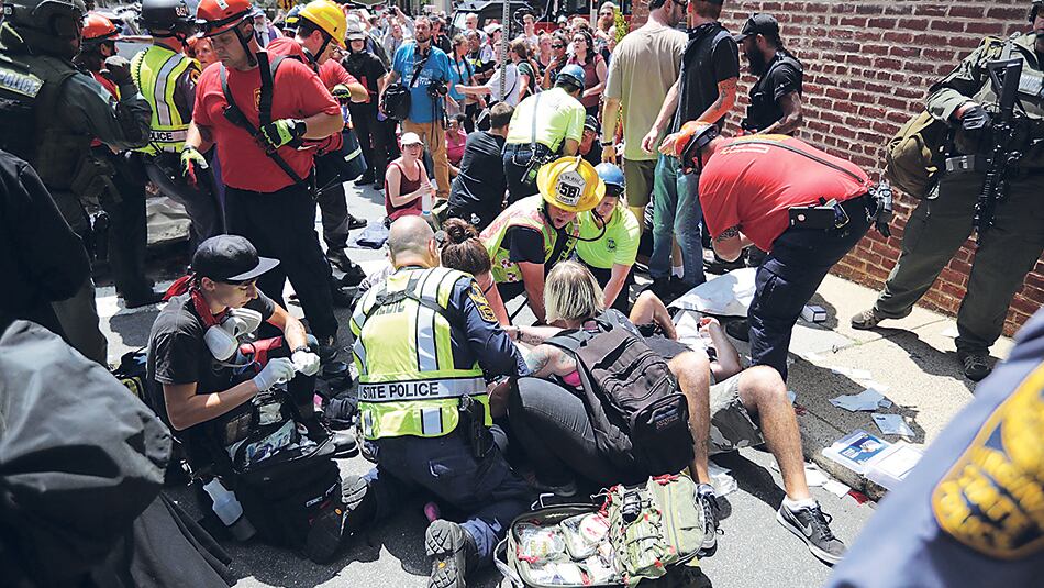 Paramédicos atienden a los heridos después de que un auto embistiera contra la multitud.