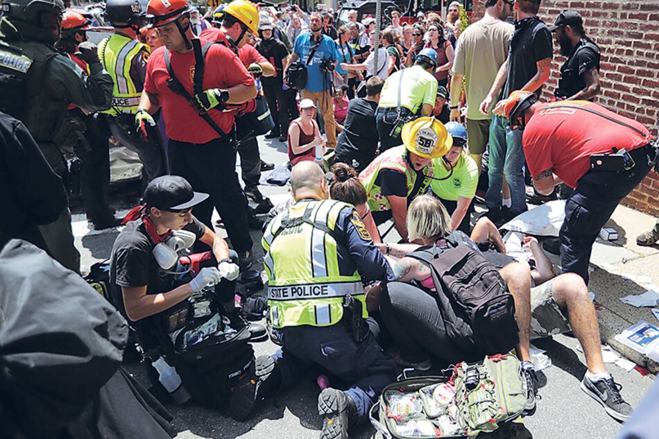 Paramédicos atienden a los heridos después de que un auto embistiera contra la multitud.