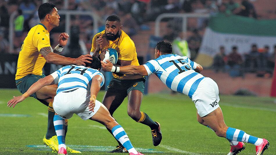 Koroibete, capitán de los Wallabies, lleva la pelota ante Moroni y Tuculet.