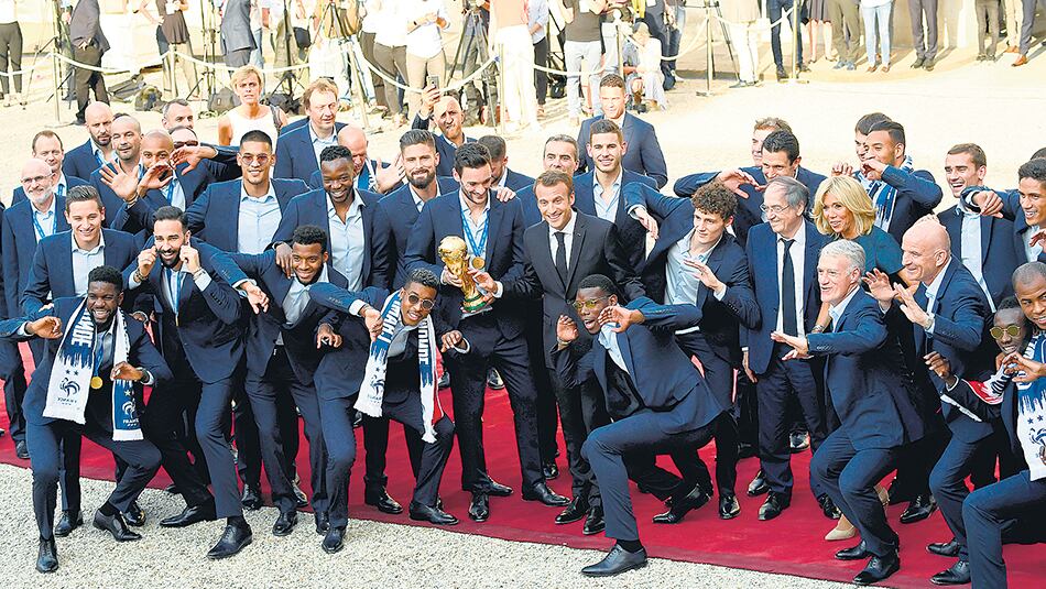 Los jugadores de Francia muestran la Copa y sus medallas junto al presidente Macron.