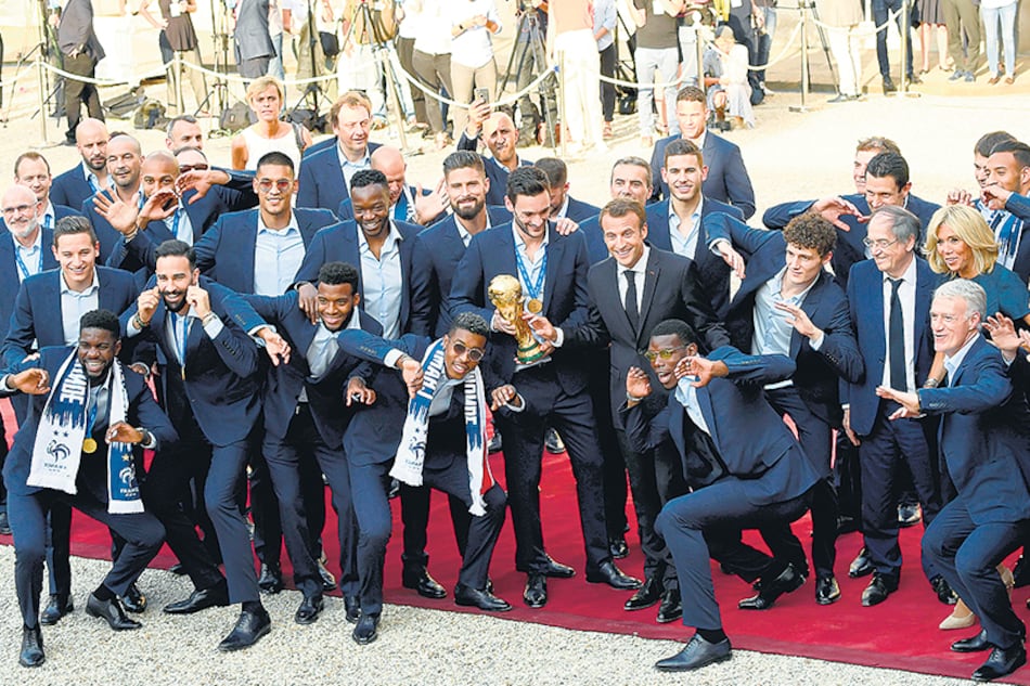Los jugadores de Francia muestran la Copa y sus medallas junto al presidente Macron.