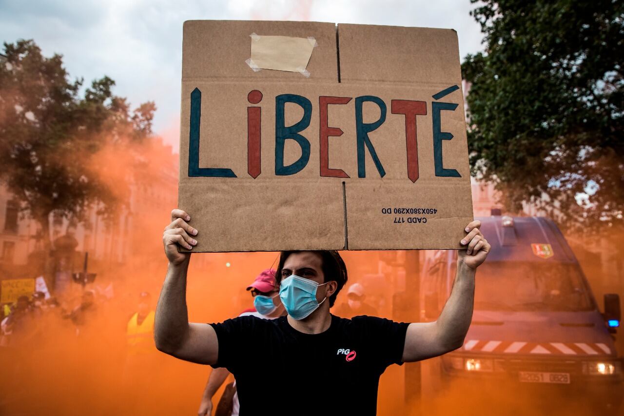 Un manifestante sostiene un cartel que dice "Libertad" durante la protesta en París