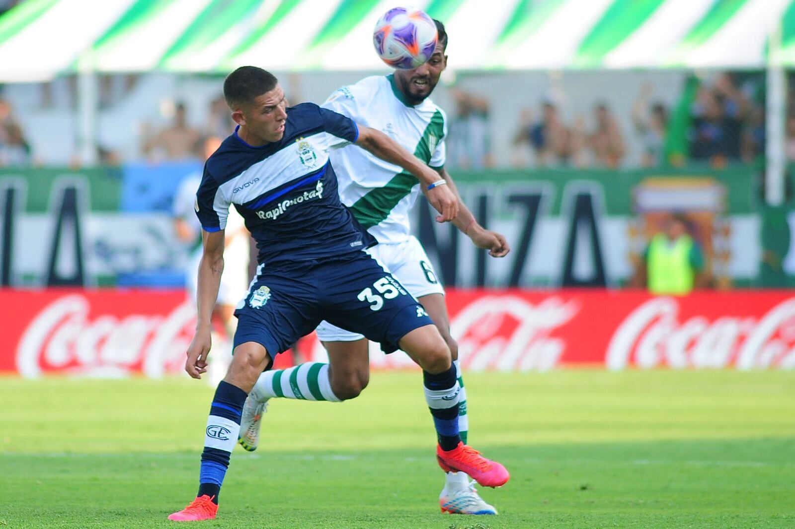El juvenil atacante Alan Sosa (Gimnasia) aguanta la marca del central Alejandro Maciel (Banfield)