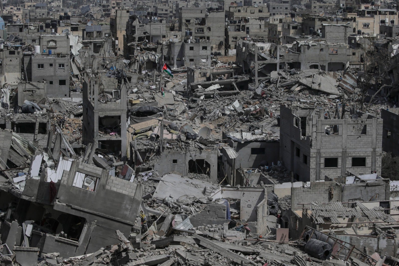 Una bandera palestina flamea en medio de las ruinas en Khan Yunis.