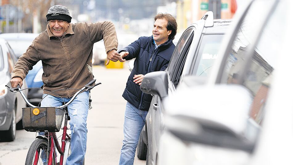 Lacalle Pou saluda a un ciclista antes de votar en Canelones.