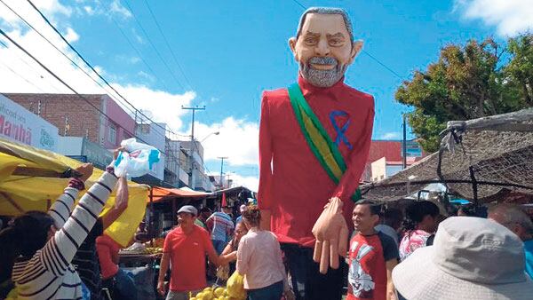 Seguidores del PT pasean un muñeco de Lula en una favela.
