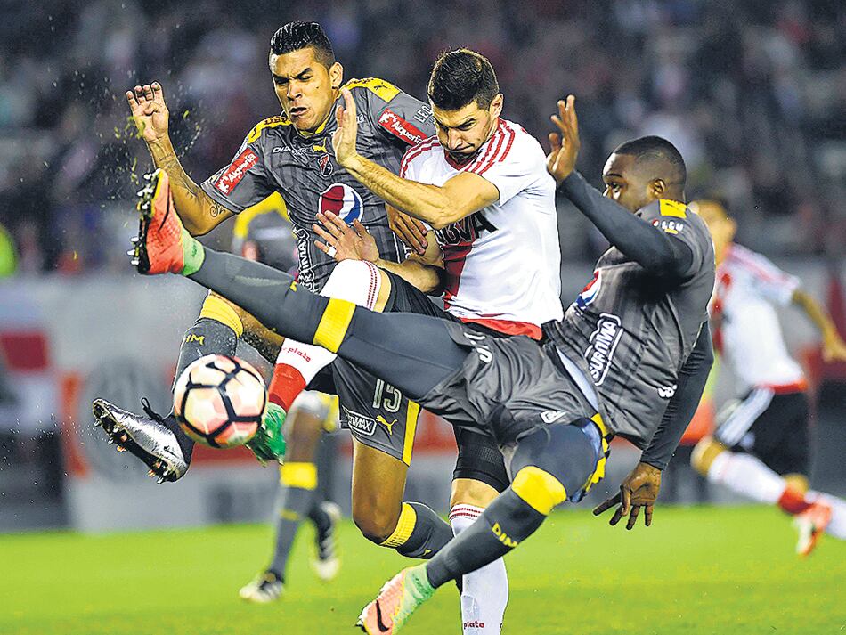 Alario intenta pasar ante la presión de Saiz y Lopera.