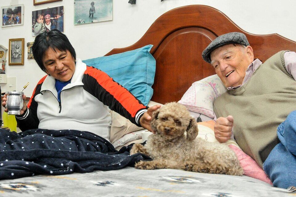 Milagro Sala, su esposo Noro y Bichi, el perro caniche, que se acomoda entre los dos y celebra cada visita con ladridos. Foto: Edgardo Varela