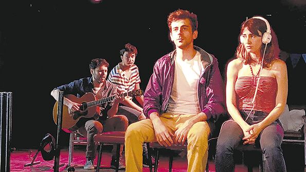 El espacio escénico está configurado como una plataforma giratoria cercana al público.