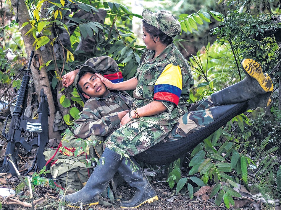 Una pareja de jóvenes guerrilleros de las FARC descansa en una de las zonas veredales.