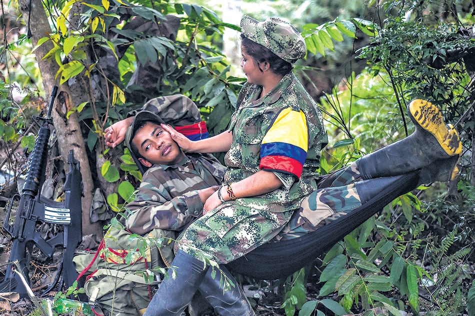 Una pareja de jóvenes guerrilleros de las FARC descansa en una de las zonas veredales.