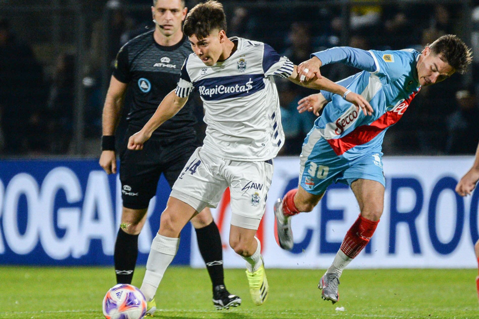 Domínguez se lleva la pelota ante Pittón; ganó el Lobo y llegó a la punta