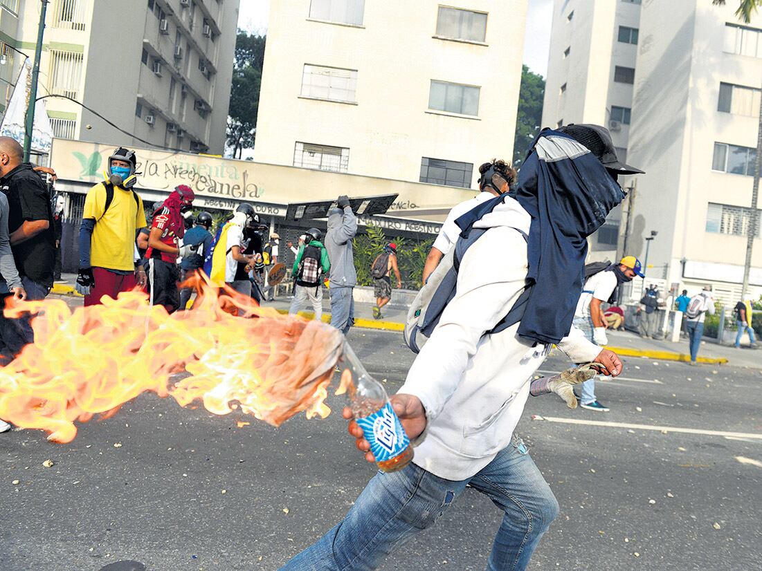 Un manifestante se prepara para lanzar una bomba Molotov en Caracas en un día de marchas a favor y en contra del gobierno.