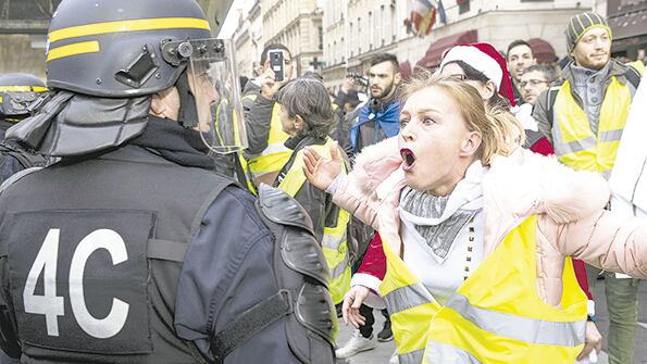 Una manifestante le gritaba a un policía durante la protesta de ayer en París.