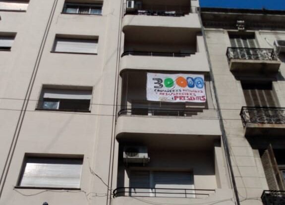 Una bandera colgada como advertencia al vecino violento: la violencia machista también espera su Nunca Más.