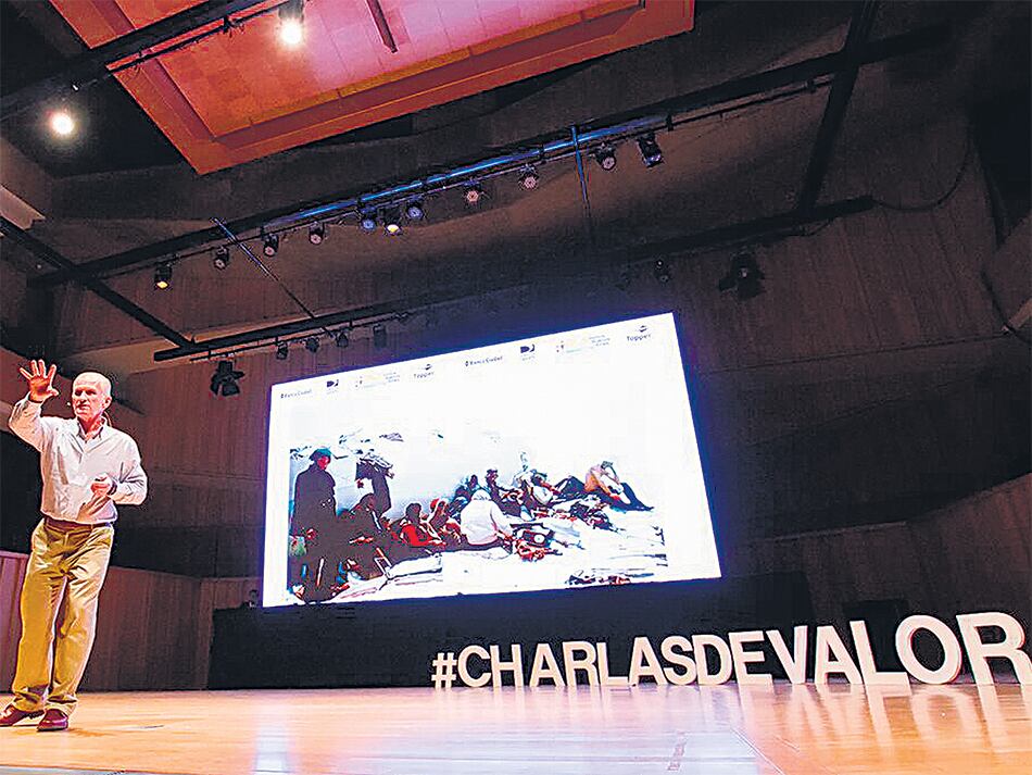 Roy Harley contando su historia en la Usina del Arte. Detrás de él se puede ver una foto del avión caído en la Cordillera de los Andes.