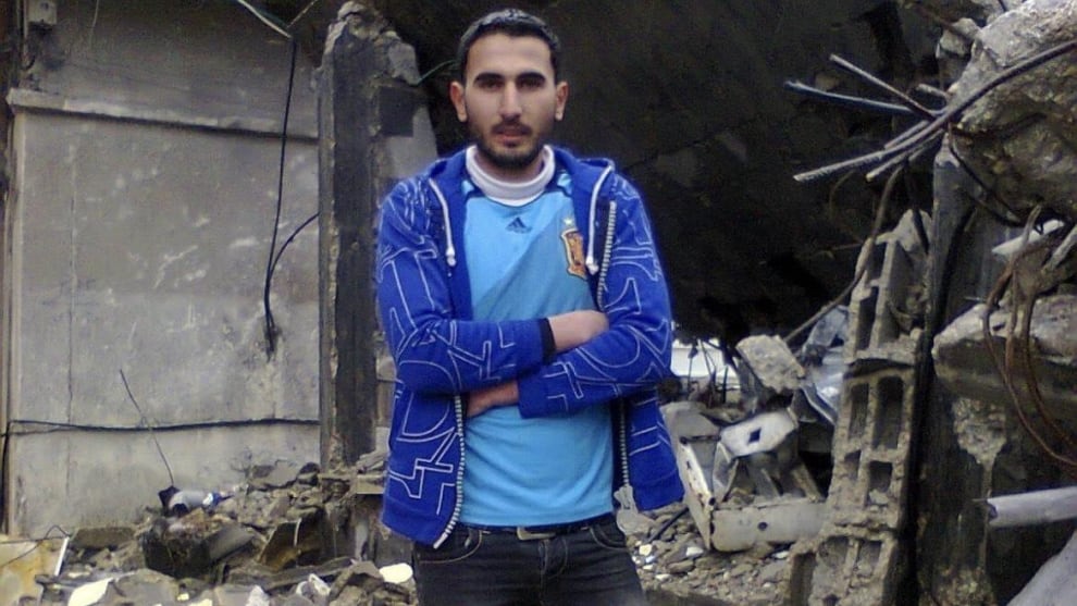 Ali Ibrahim frente a un edificio en ruinas en Gaza