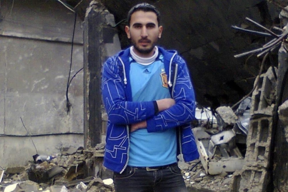 Ali Ibrahim frente a un edificio en ruinas en Gaza