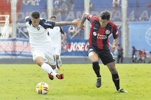 Bustos lleva la pelota ante la marca de Botta.