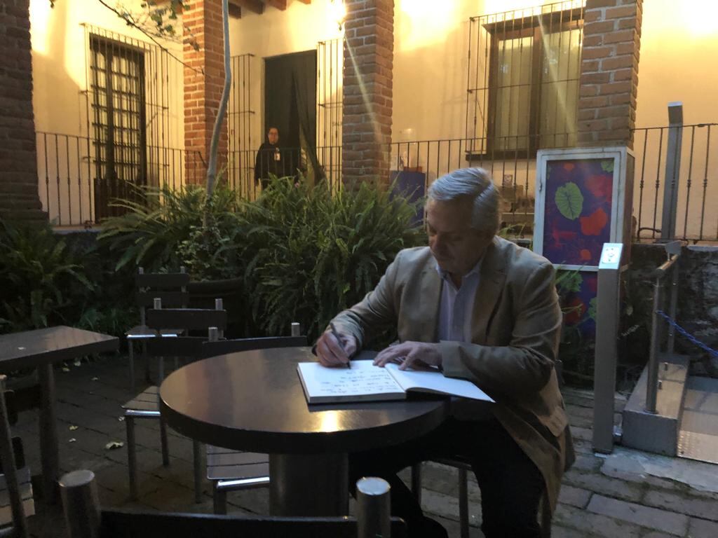 Fernández firmando el libro de visitas de la casa de Frida Kahlo.