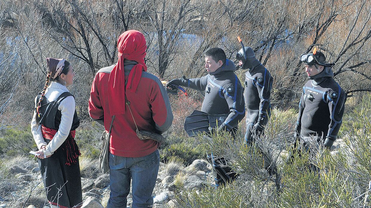 Buzos y miembros de la comunidad mapuche durante el primer operativo de rastrillaje sobre el río Chubut.