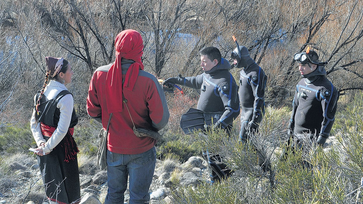 Buzos y miembros de la comunidad mapuche durante el primer operativo de rastrillaje sobre el río Chubut.