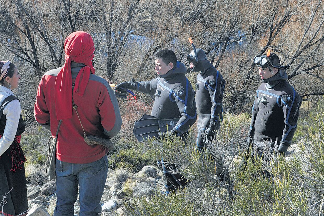 Buzos y miembros de la comunidad mapuche durante el primer operativo de rastrillaje sobre el río Chubut.